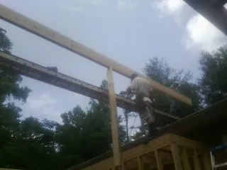 Carpenter setting a ridge beam over a new addition frame — Ice Dam Removal by Roofing Brothers in Cleves