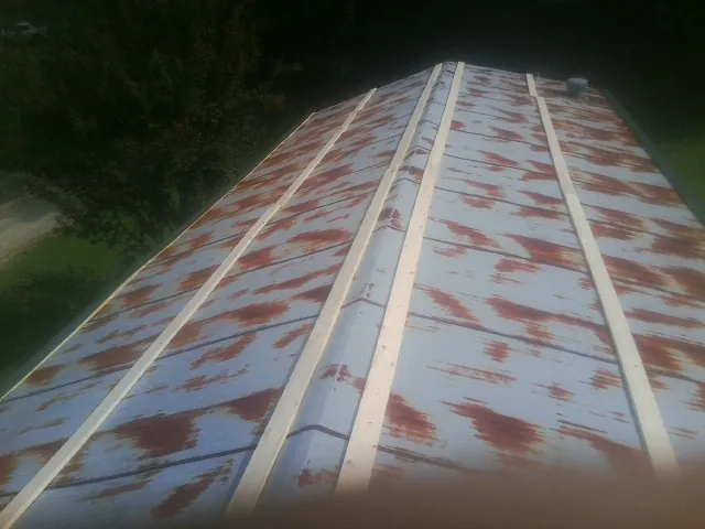 Rusted metal roof panels with new wood purlins before replacement — Storm Damage Roof Repair in Cleves by Roofing Brothers
