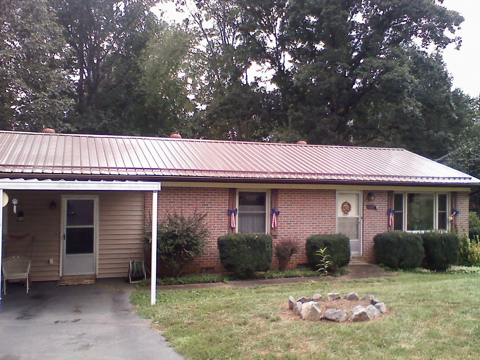 Bronze metal roof and carport on a brick ranch home — Roof Repair work by our crew in Cleves